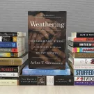 Weathering book cover showing in center, framed on either side by stacks of other books